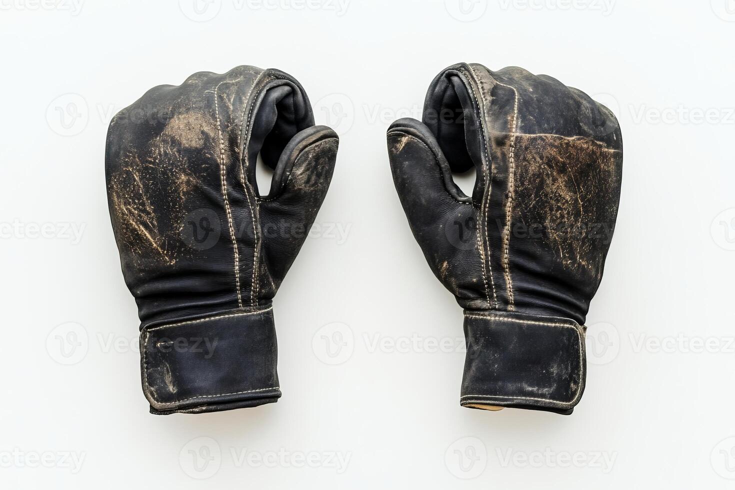 A pair of worn vintage leather boxing gloves displayed on a white background, highlighting their rustic appeal and historical significance. photo