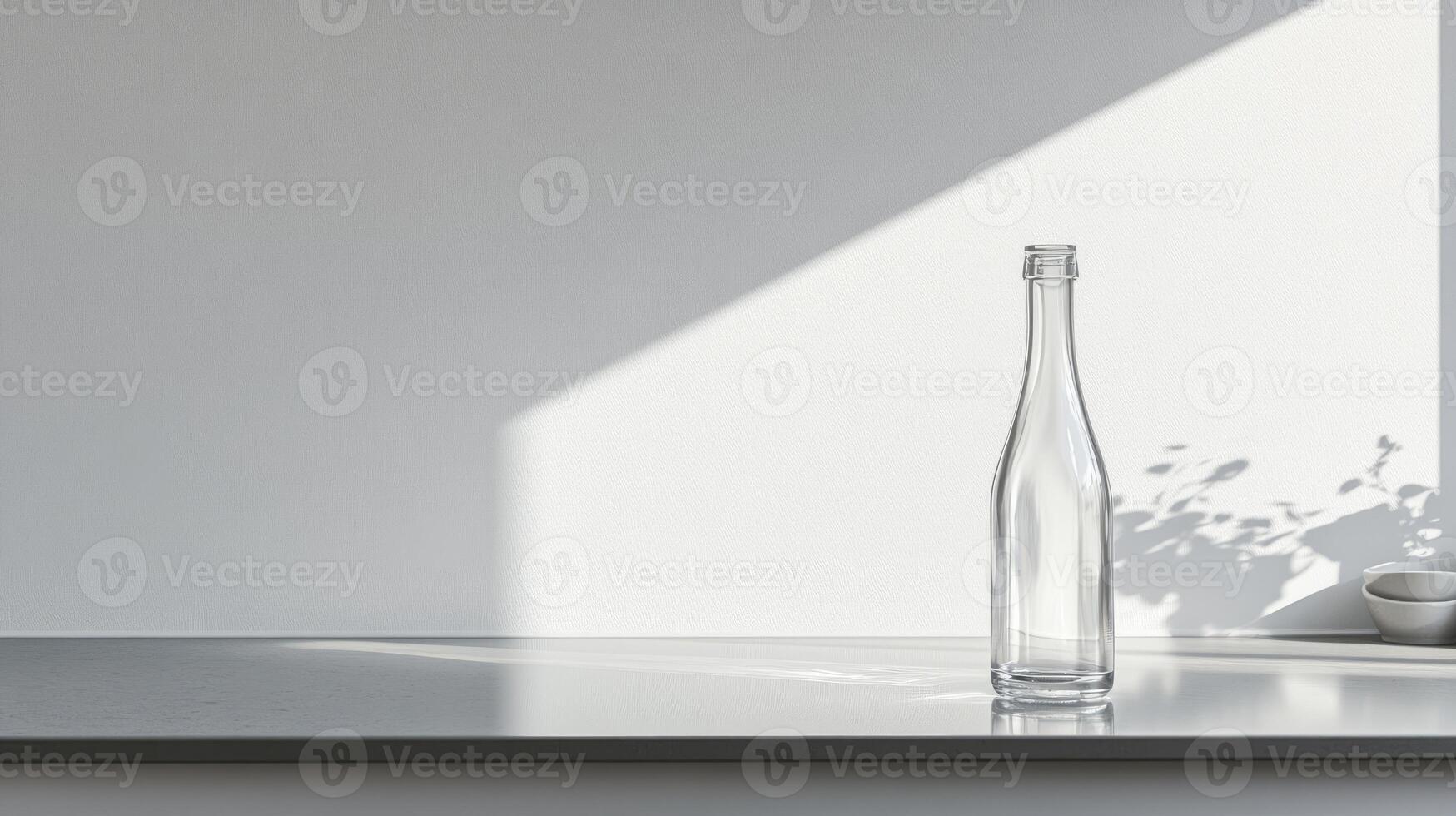 A clear glass bottle on a minimalist countertop with sunlight casting soft shadows, perfect for modern design and simplicity themes. photo