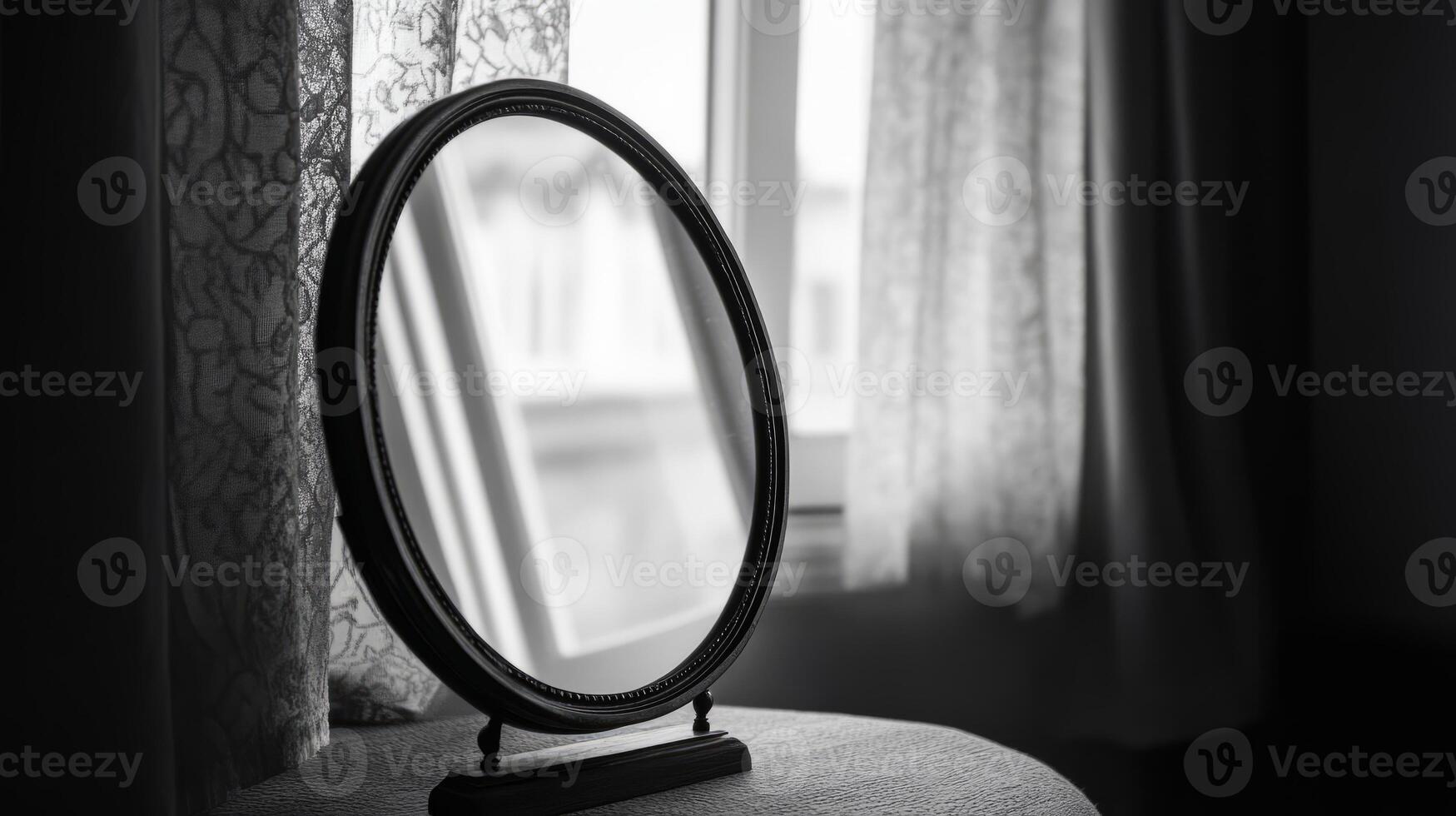 A vintage mirror on a table with lace curtains, capturing soft natural light in a black and white setting. photo