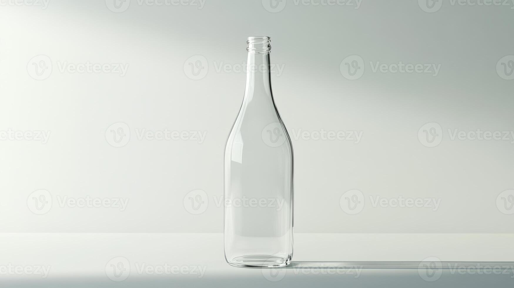 A clear glass bottle is sitting on a table. The bottle is empty and has a clear glass top photo