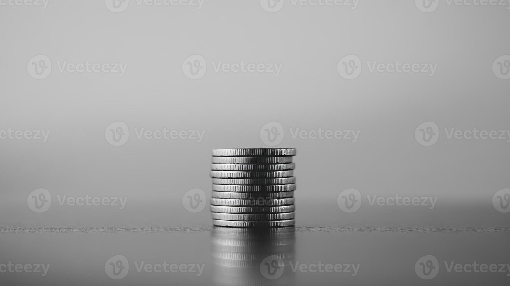 Monochrome Stack of Silver Coins Symbolizing Wealth and Financial Prosperity on Reflective Surface photo