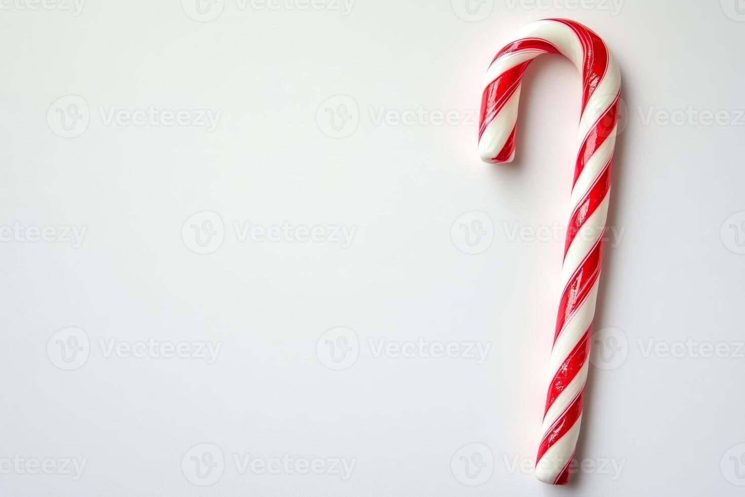 Red and white candy cane is on a white background. The candy cane is the main focus of the image photo