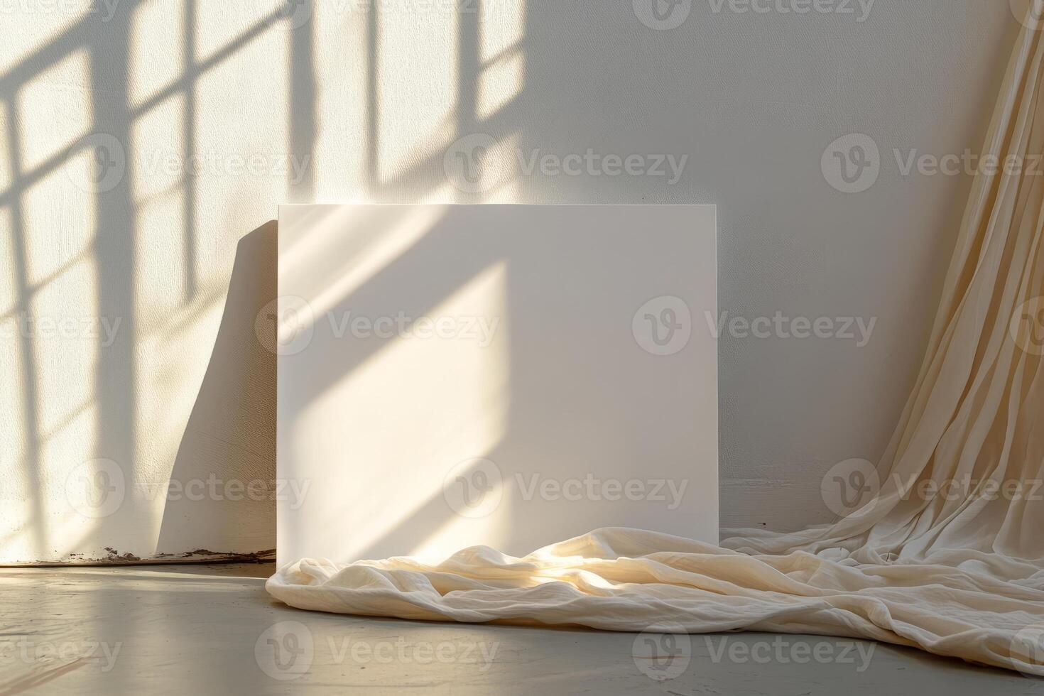 A blank canvas illuminated by sunlight, surrounded by soft draped fabric, creating a serene and minimalist interior scene. photo