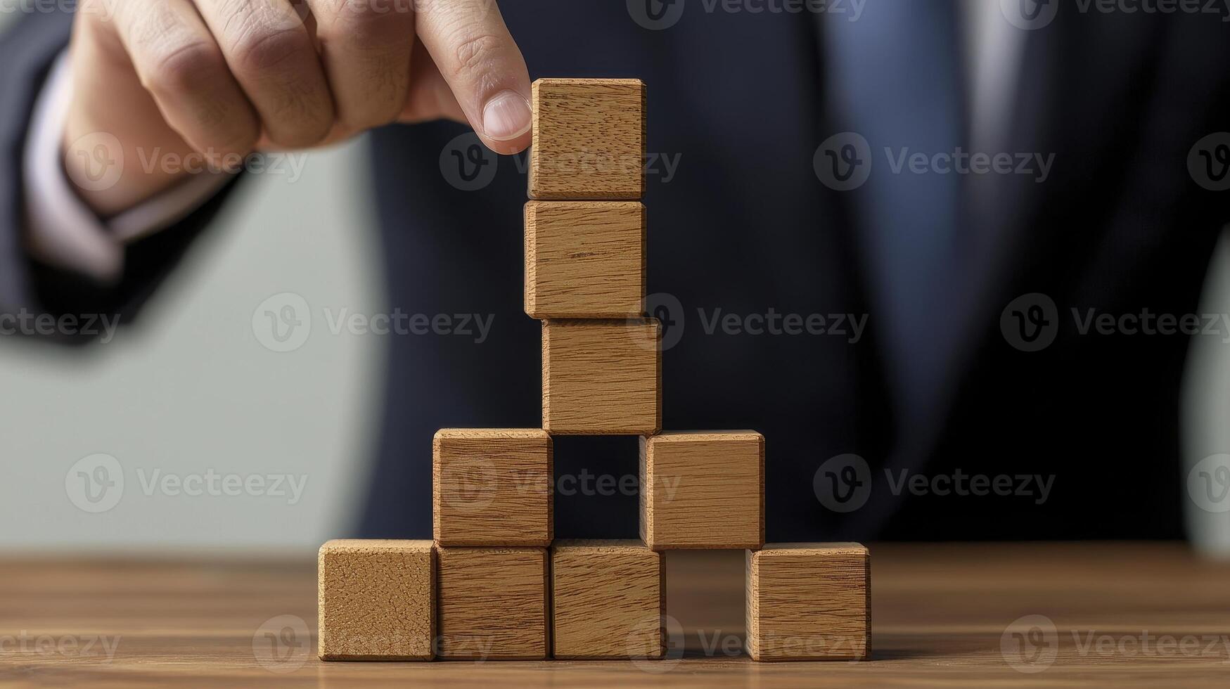 Strategic Planning and Business Growth A Conceptual Image of Wooden Blocks Stacked to Represent Building Success, Stability, and Progress, showcasing a Businessman's Hand Carefully Placing a Block photo