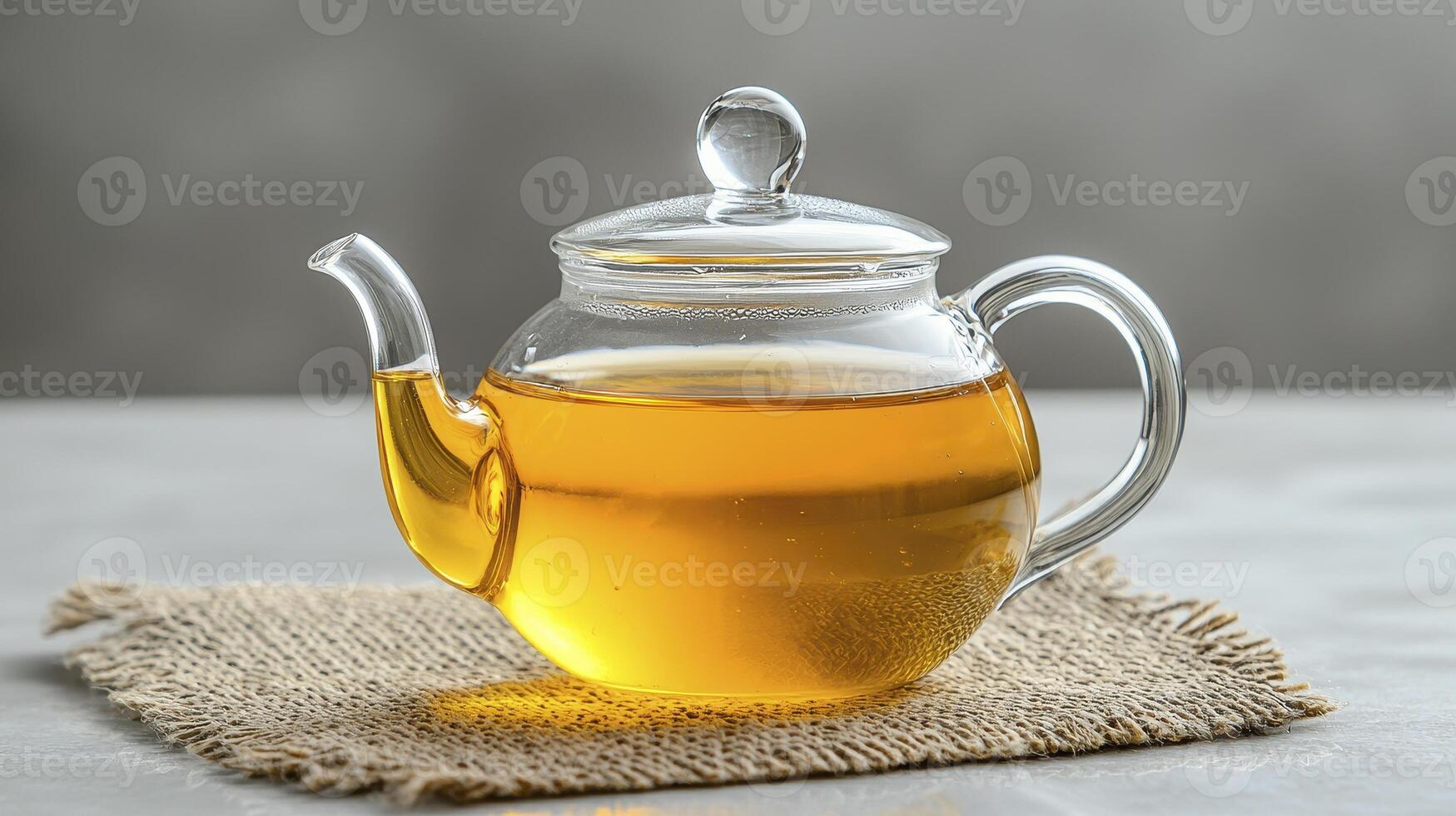 Golden Elixir A Crystal Clear Teapot Filled with Amber Brew, Inviting Warmth and Serenity in Every Sip Experience the Delicate Dance of Flavors as Steam Gently Rises, Carrying Whispers of Tranquility photo