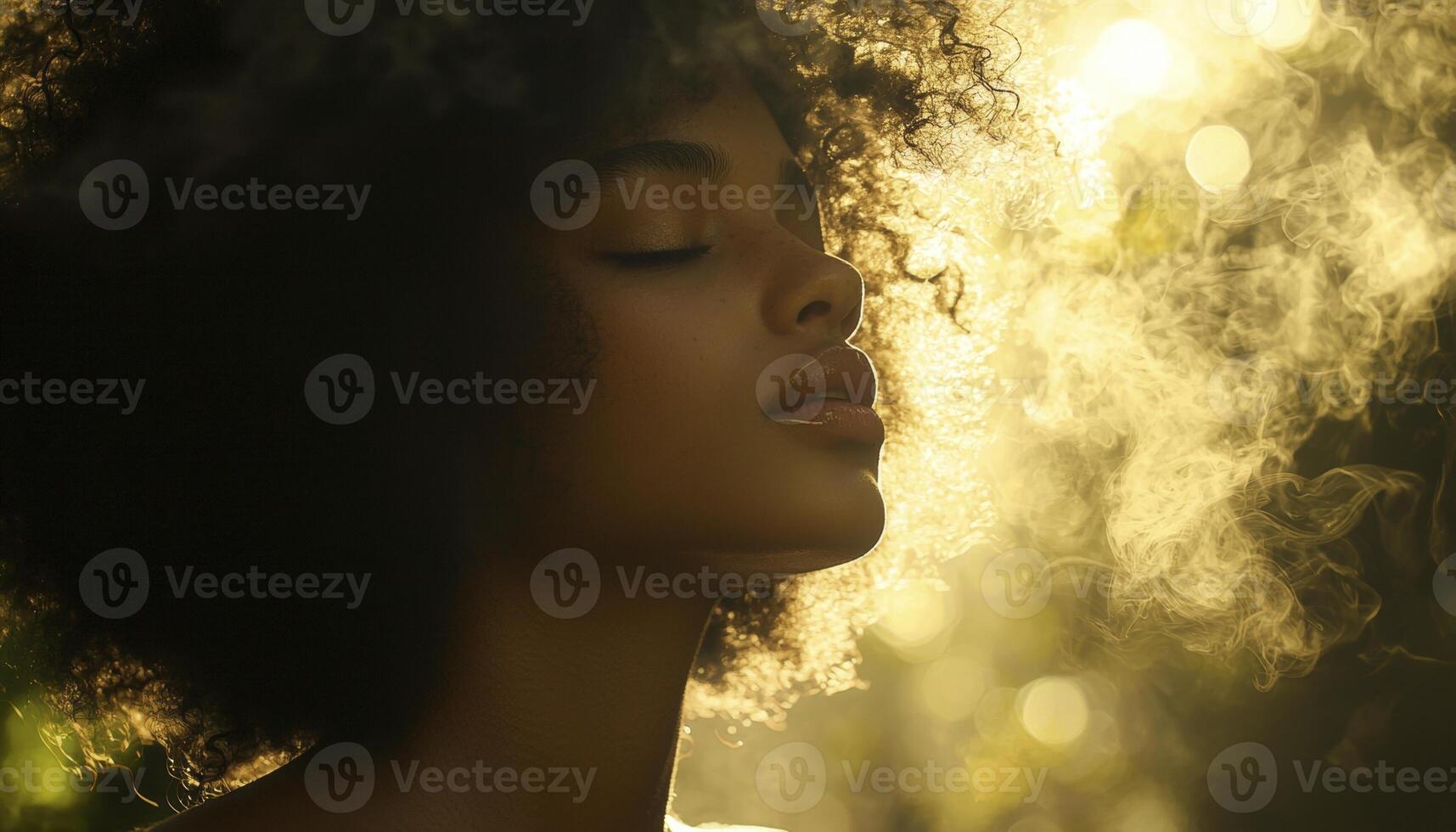 In a realm where light dances with ethereal grace, a curly-haired woman finds solace in a moment of pure magic Bathed in a soft, golden glow, she closes her eyes, surrendering to the enchantment that photo