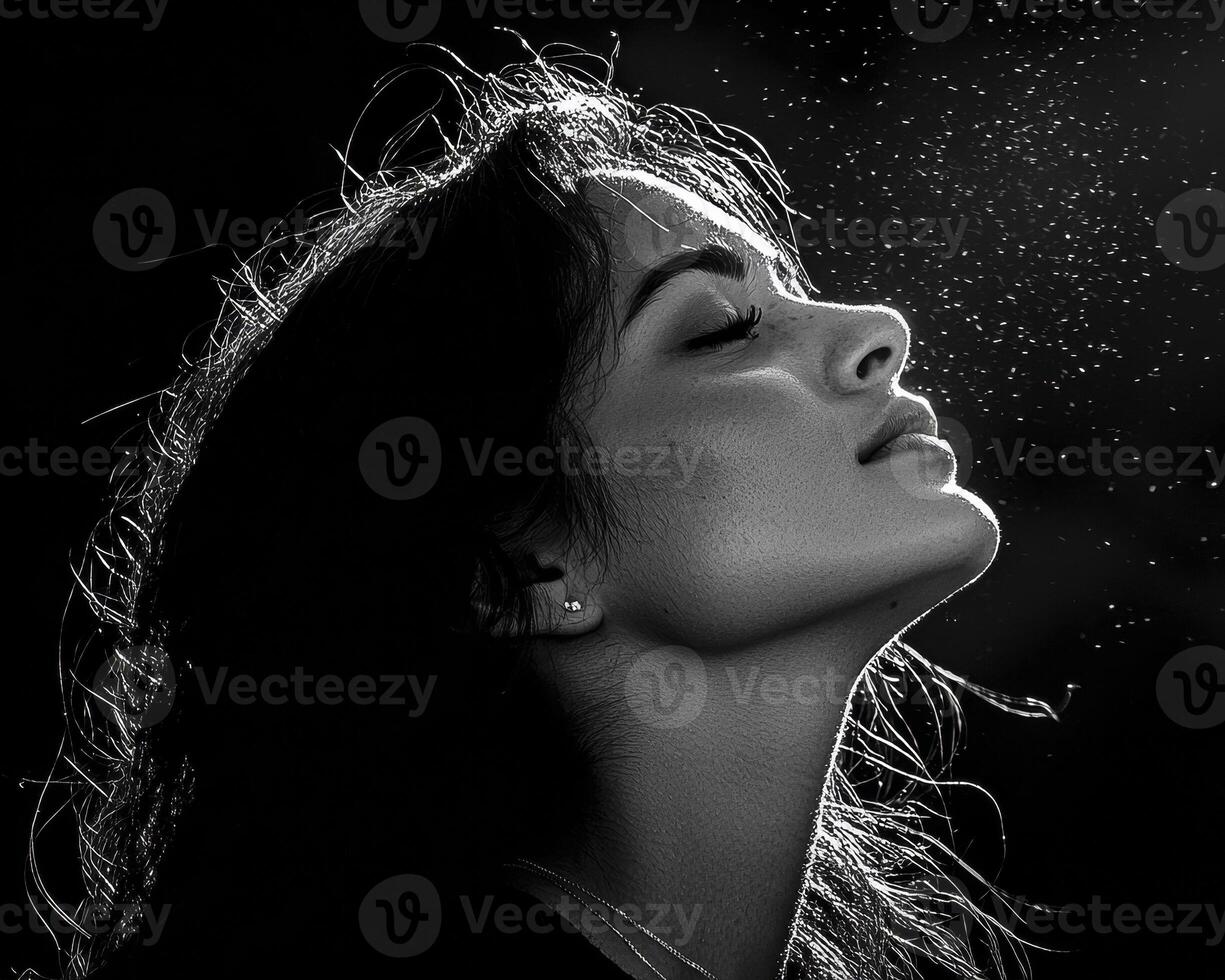In the realm of monochrome artistry, a captivating portrait emerges, revealing a woman's serene countenance bathed in ethereal light Her delicate features are accentuated by the stark contrast photo
