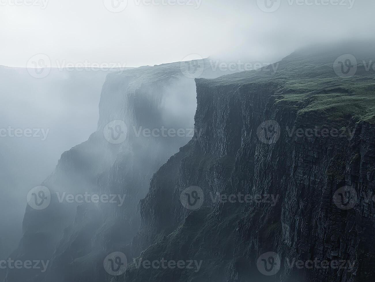 Enshrouded in mystery, a colossal canyon unveils its majestic steep walls, sculpted by the relentless hand of erosion over eons The dense fog adds an ethereal quality, blurring the lines between photo