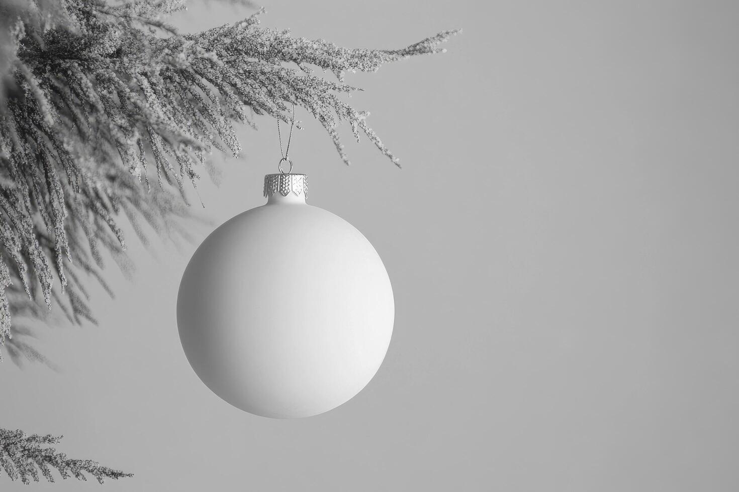 A white christmas ball hanging from a tree photo