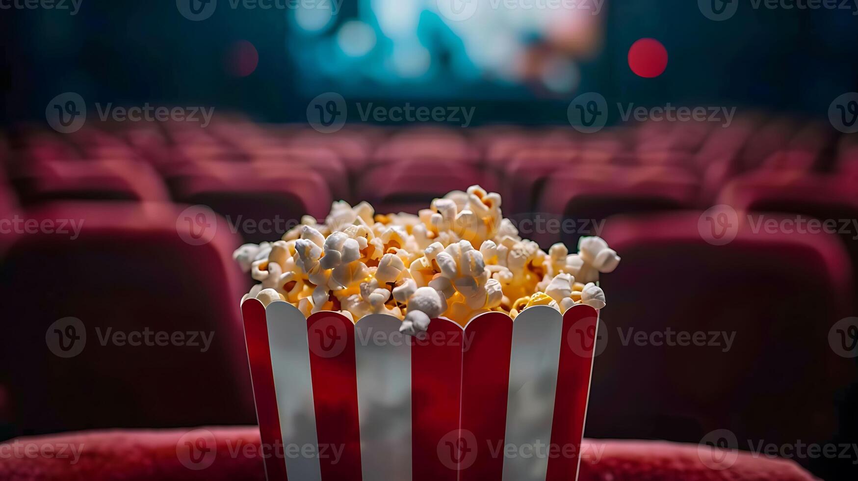 Popcorn in a red and white striped box on a red chair photo