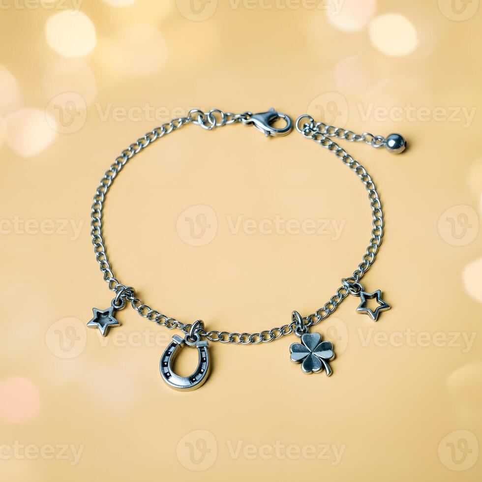 Silver charm bracelet with horseshoe four leaf clover and star charms on soft golden bokeh background photo