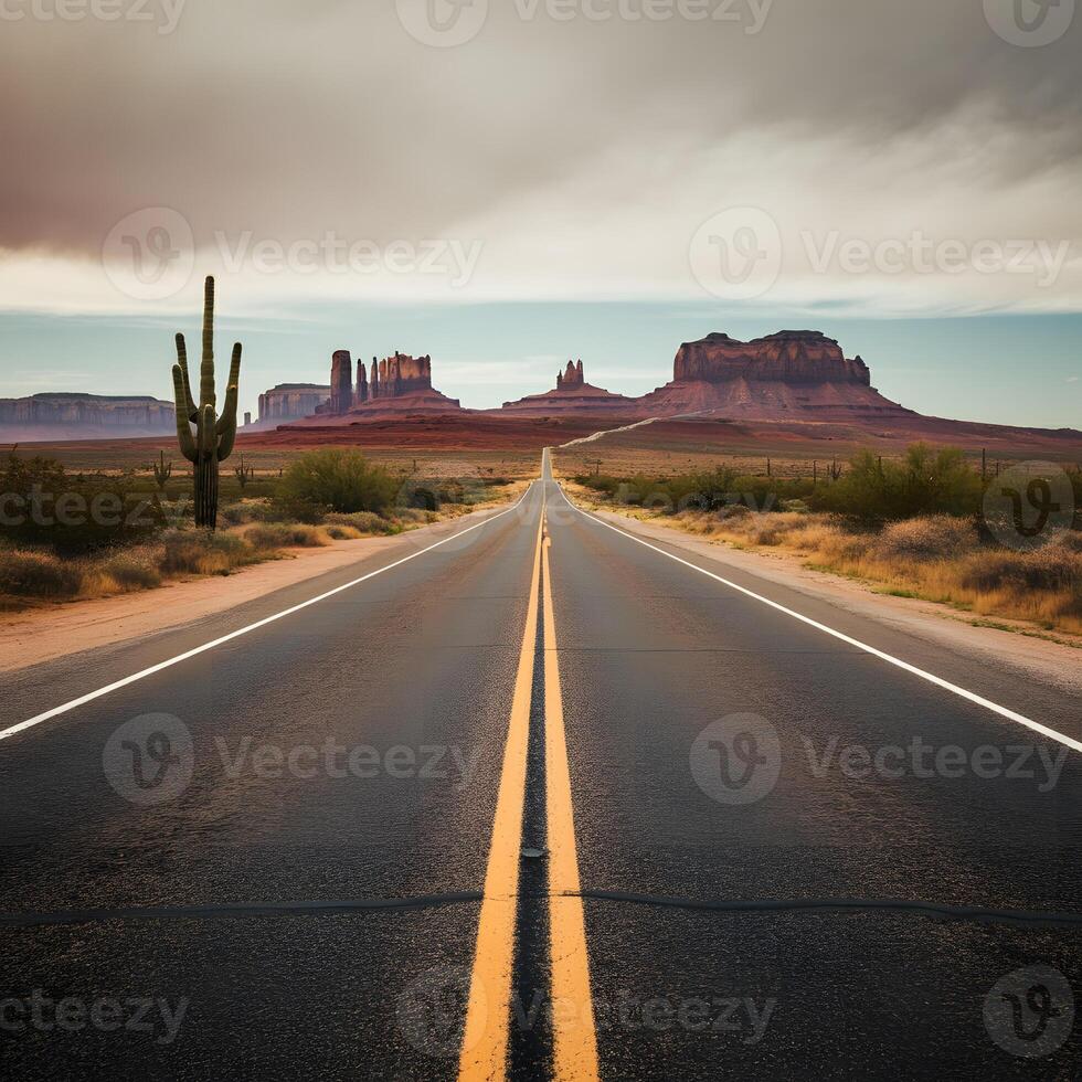 Long straight desert highway with yellow road lines cactus and rock formations under cloudy sky American southwest roadtrip photo