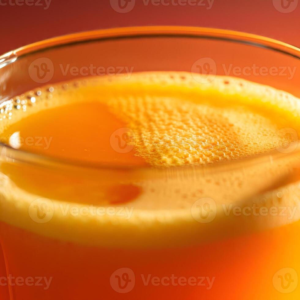 Close up of foamy orange juice in a transparent glass with soft bokeh background and fresh citrus tones photo