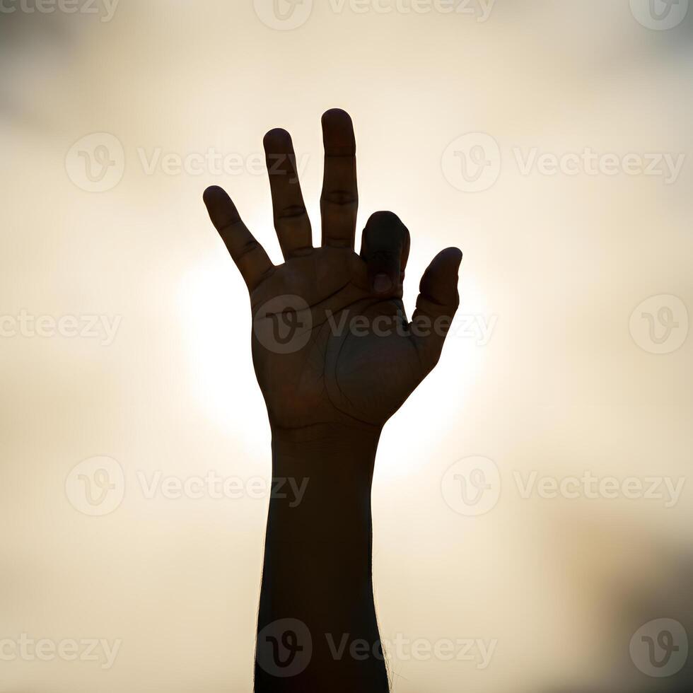 Outstretched hand reaching towards warm sunlight with bokeh effect symbolizing hope new beginnings photo