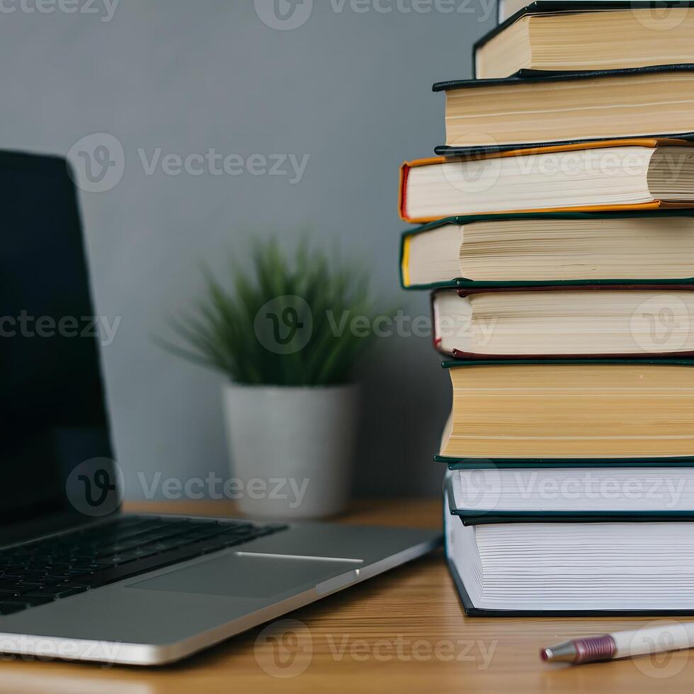 Stack of books and open laptop on a wooden desk symbolizing knowledge education and learning workspace academic study research photo