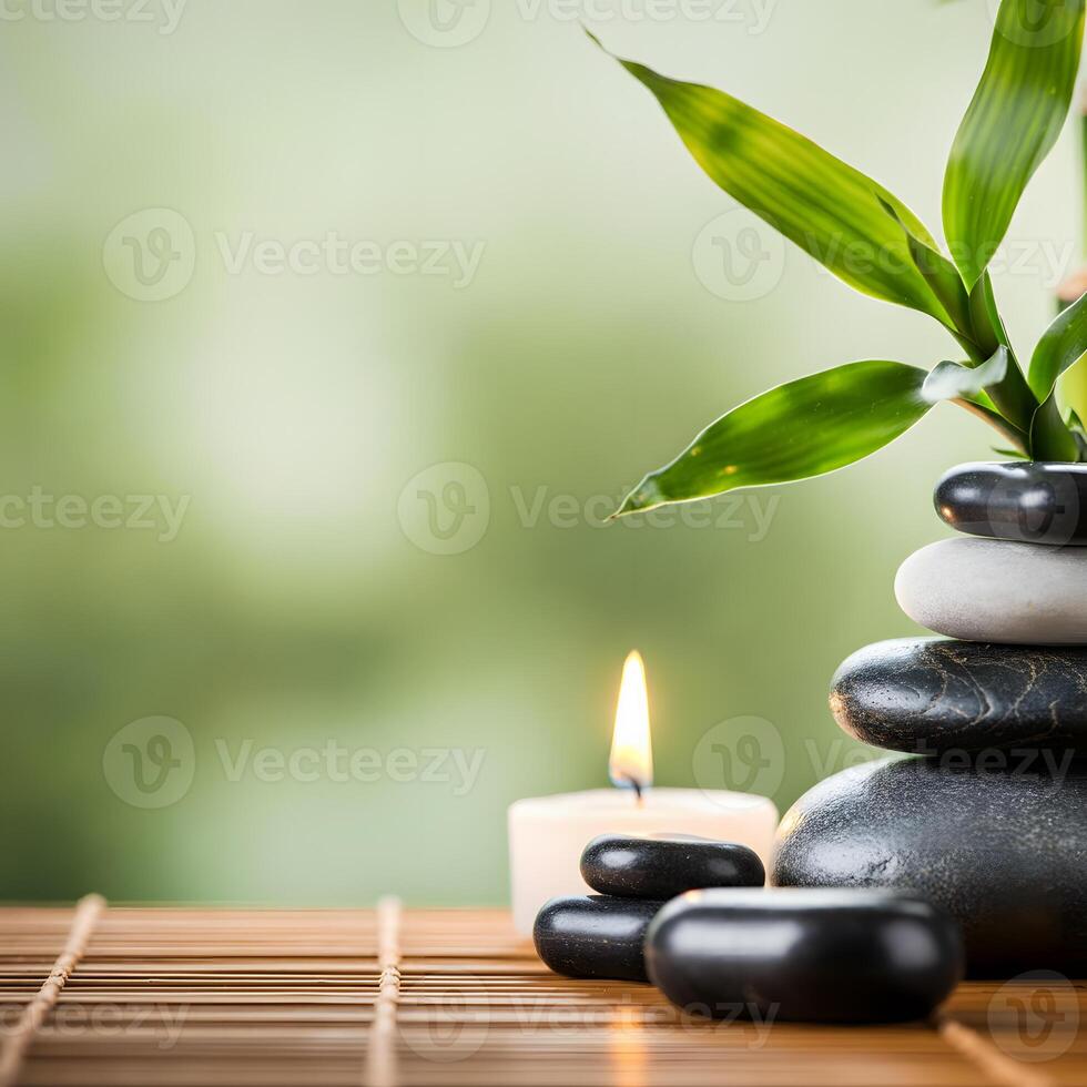 Spa and wellness concept with stacked massage stones candle and bamboo plant on a wooden mat with green background photo