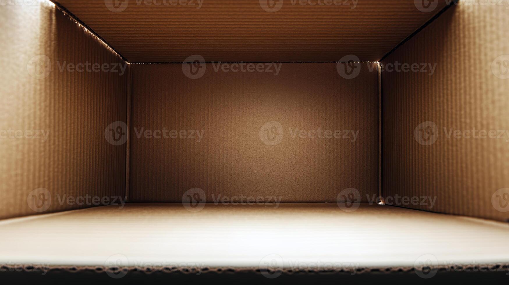 Empty brown cardboard box interior with corrugated texture and warm lighting photo