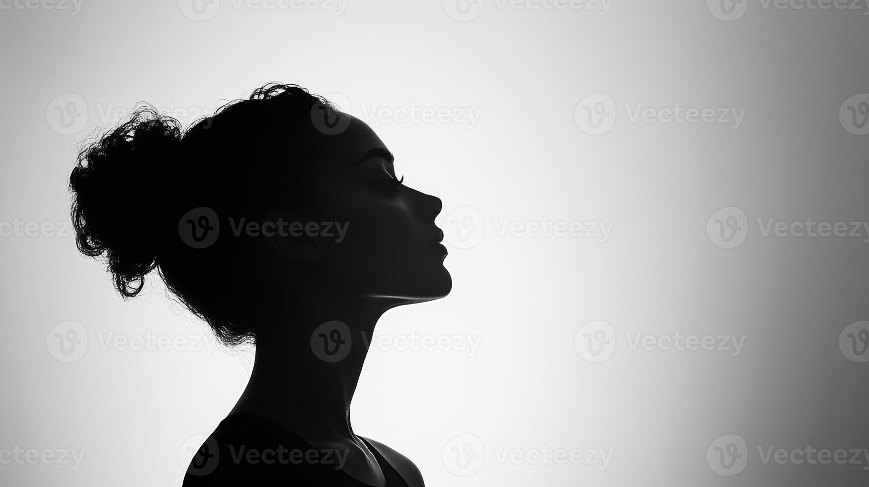 Silhouette of young african female in profile with curly hair against soft light photo