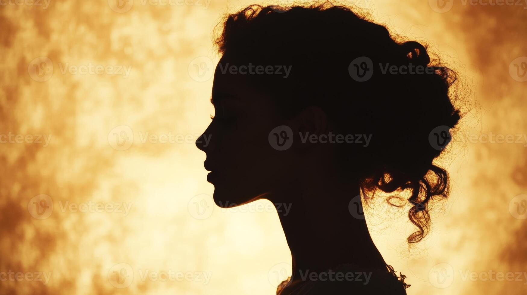 Silhouette of young african female with curly hair against warm background photo