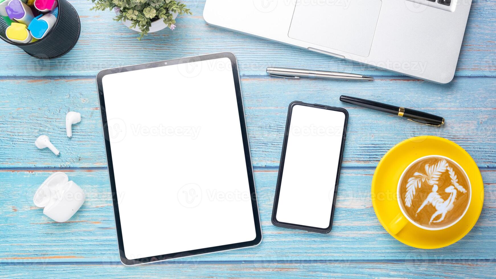 Wooden desk workplace with blank screen smart phone and tablet, laptop, pen, earphone and cup of coffee, Top view flat lay. photo