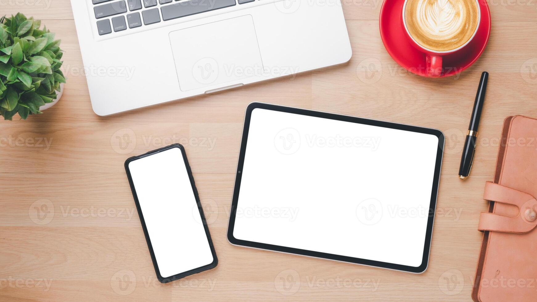 Office wooden desk workplace with blank screen tablet and smartphone, laptop, pen, notebook and cup of coffee, Top view flat lay. photo