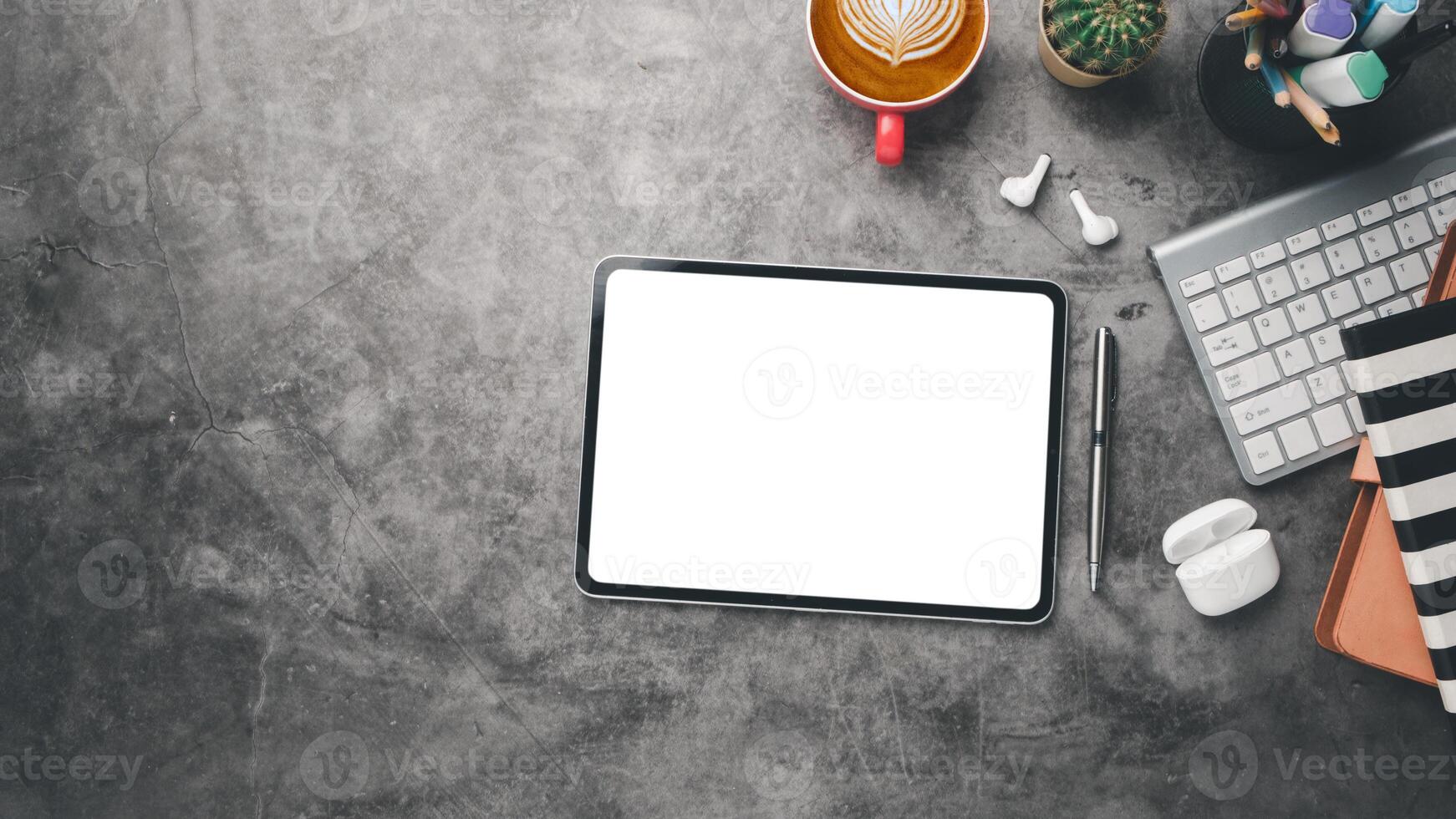 Office desk workplace with blank screen digital tablet, earphone, keyboard computer, notebook and cup of coffee, Top view flat lay with copy space. photo