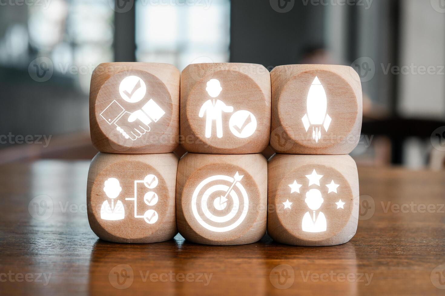 Wooden blocks with icons symbolizing commitment, teamwork, and success, arranged on a wooden table. photo