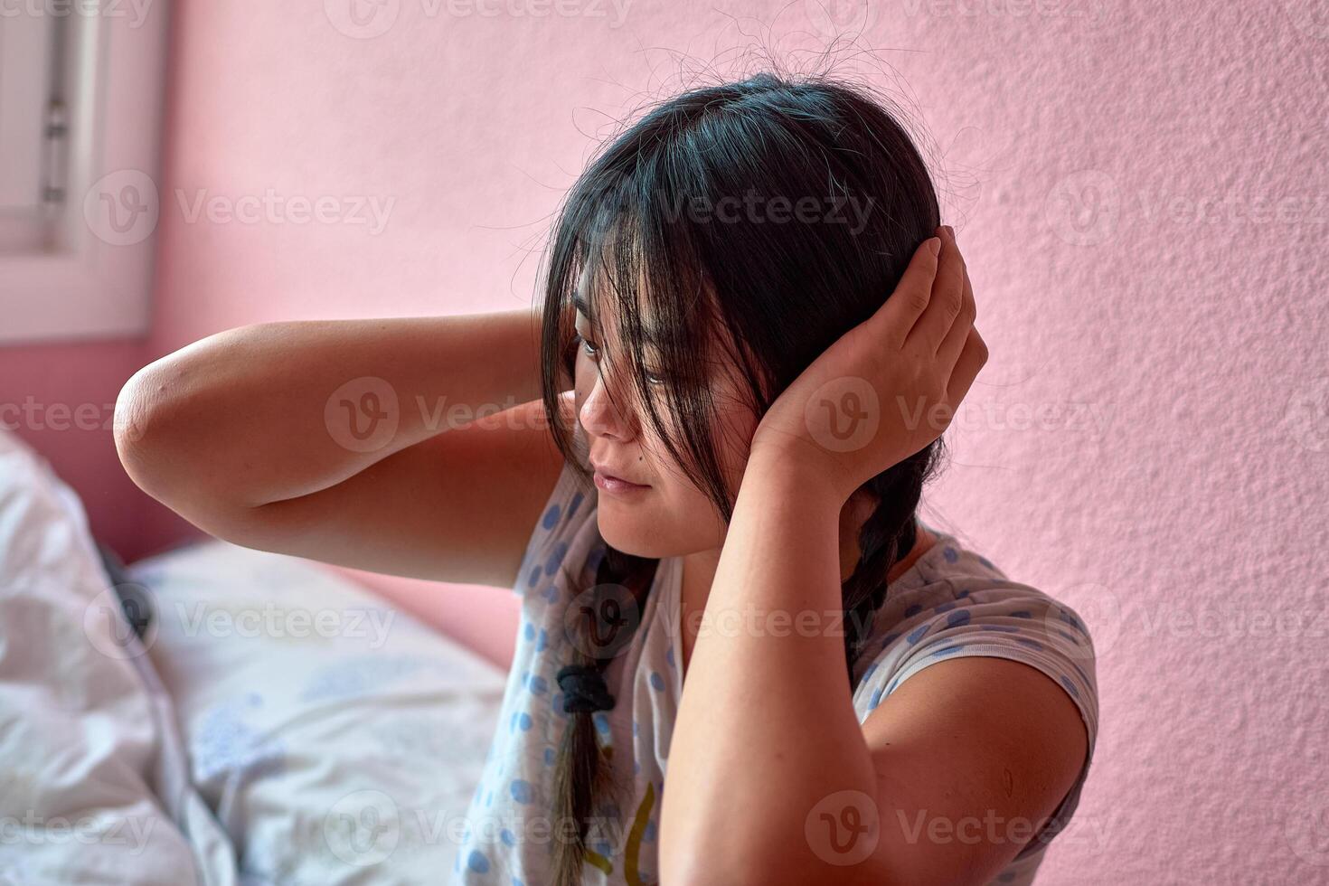 A young autistic Chinese girl with pigtails reacts to harsh noises photo
