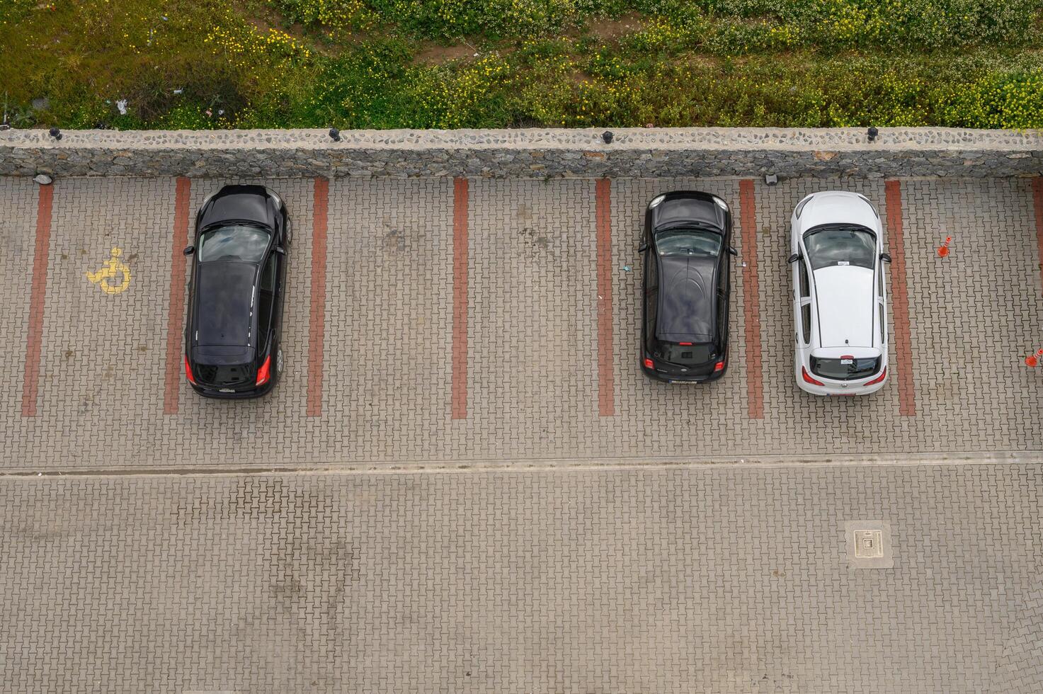 Gaziveren Cyprus -01.03.2025 Parking lot with vehicles organized in lines beside green fields on a cloudy day photo