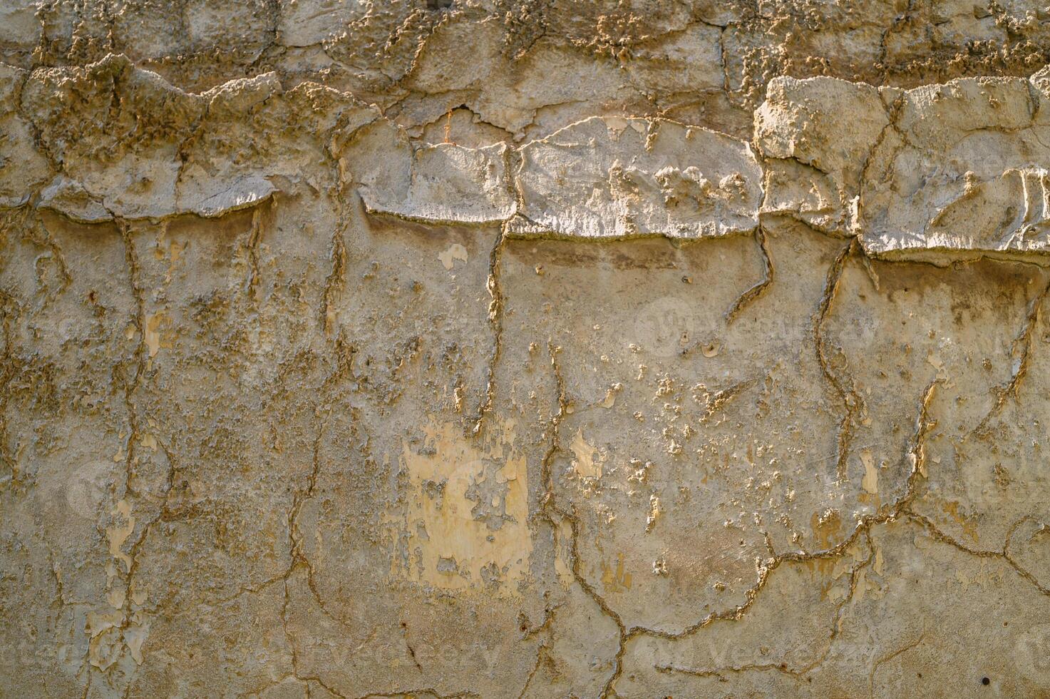 Weathered texture reveals history of an aged wall in a sunlit urban setting photo