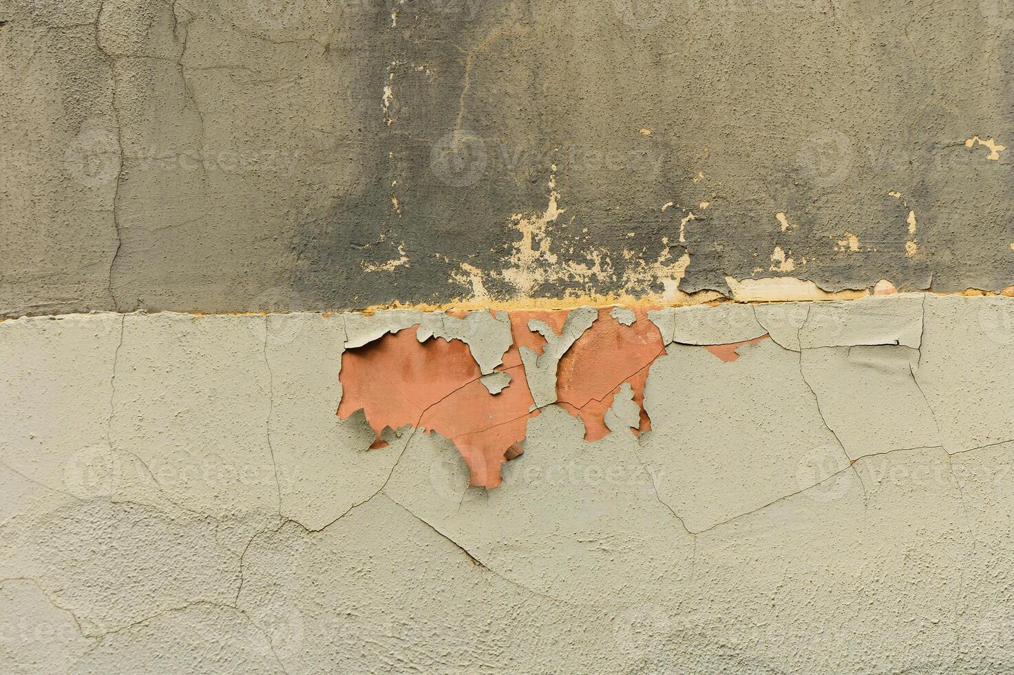 Peeling paint reveals layers of history on a weathered wall in an old urban setting photo