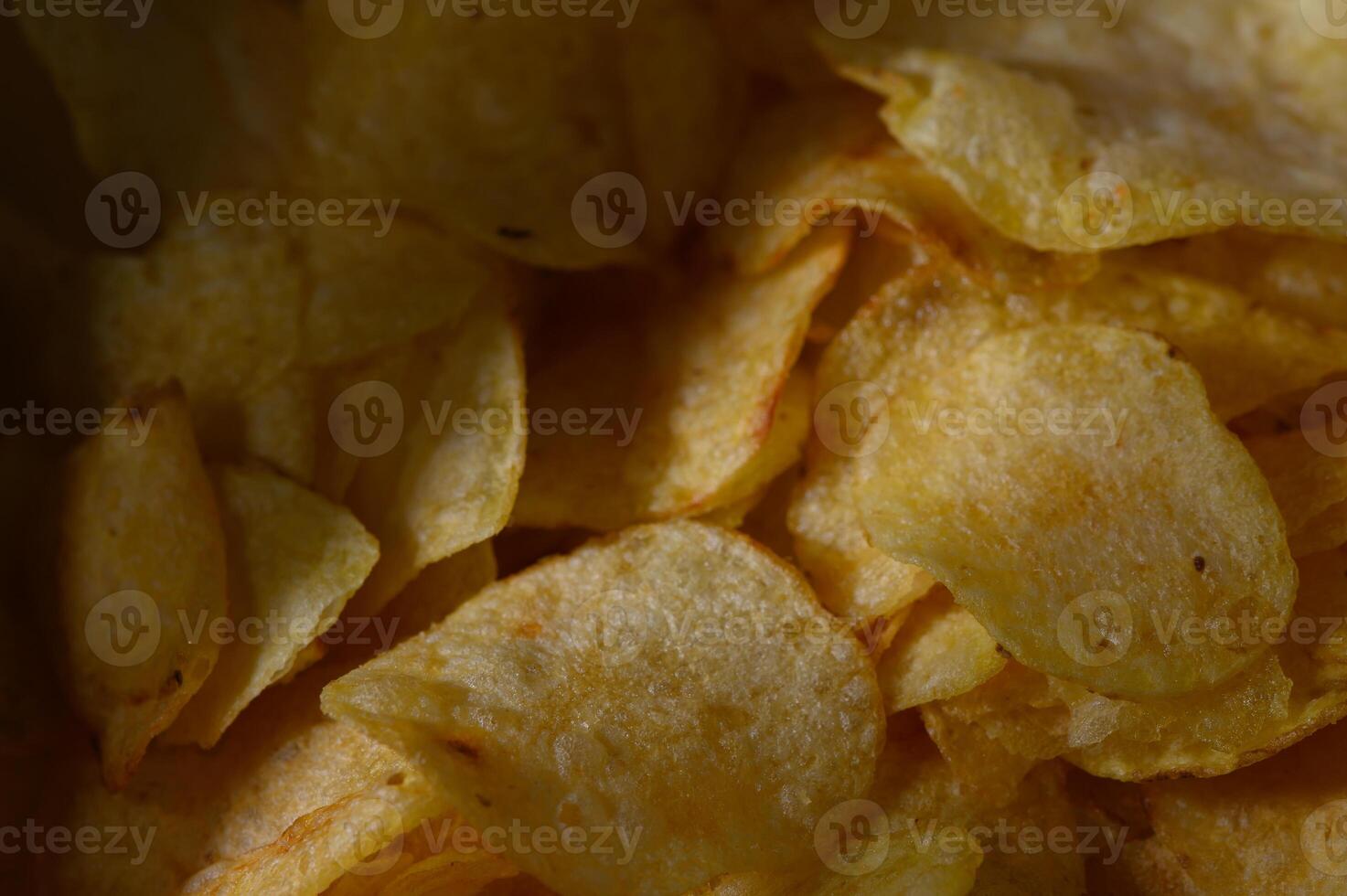 Crispy golden potato chips piled high in a warm, cozy setting photo