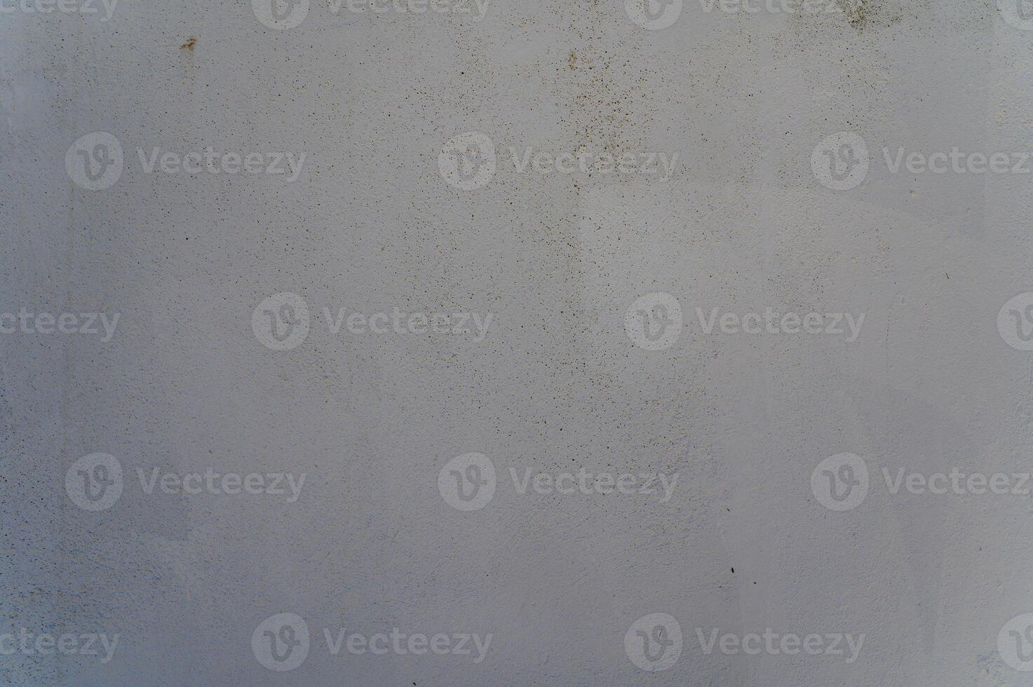 Textured wall exhibits subtle hues and imperfections in a soft, muted light during the early afternoon photo