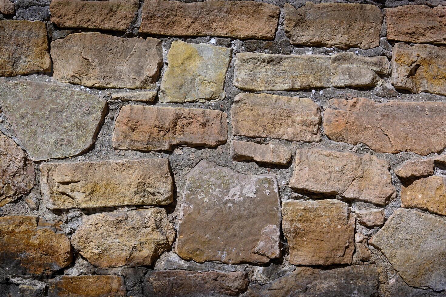 Textured wall of weathered stones creates a rustic charm in an ancient structure photo