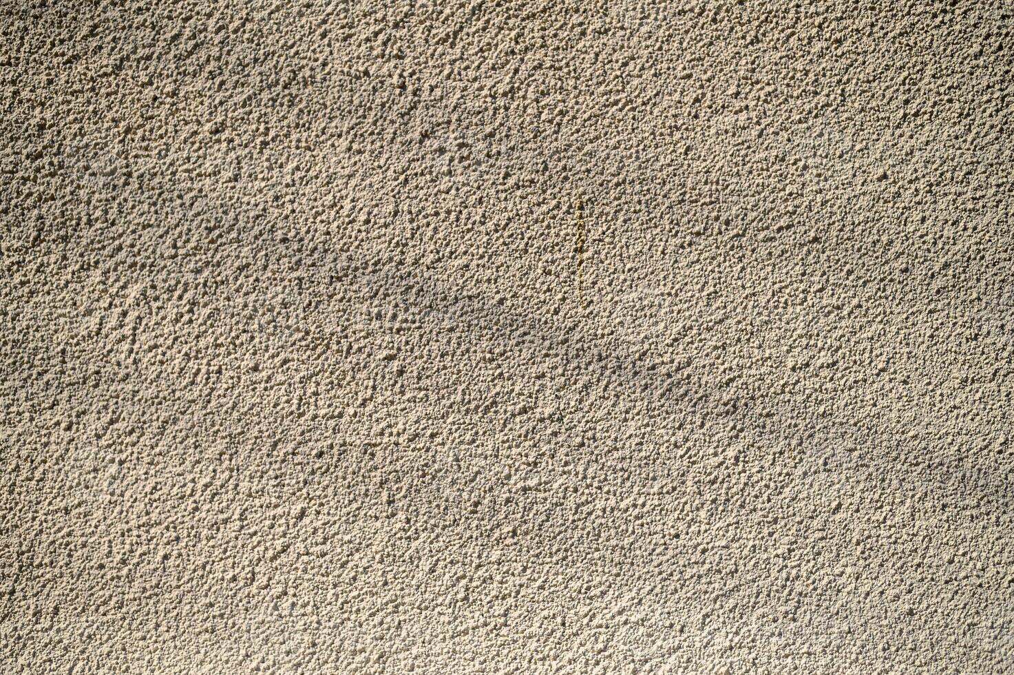 Textured wall illuminated by soft sunlight, showcasing intricate patterns and subtle shadows photo
