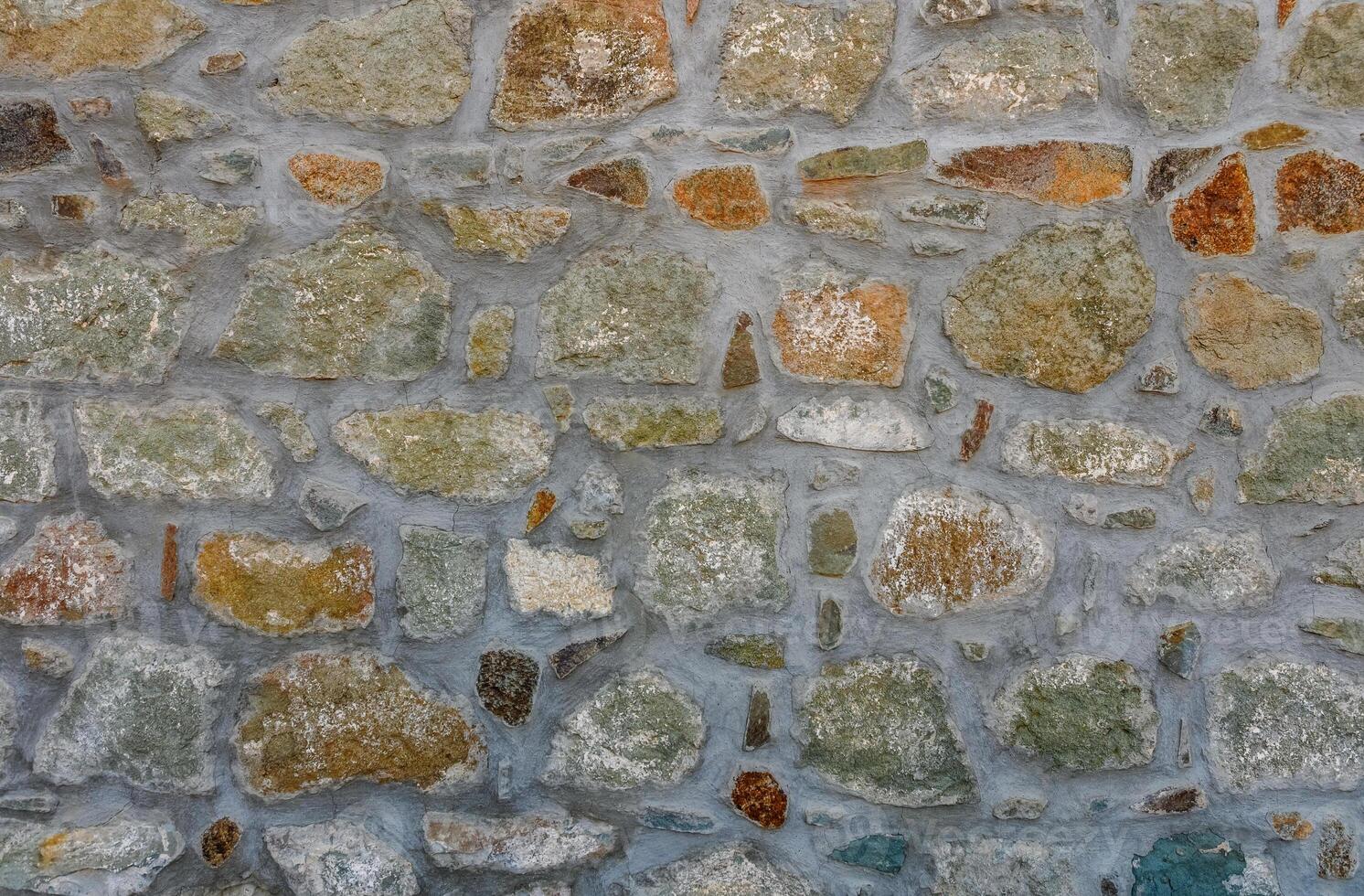 Exploring textures and colors of an ancient stone wall in a quaint village during golden hour photo
