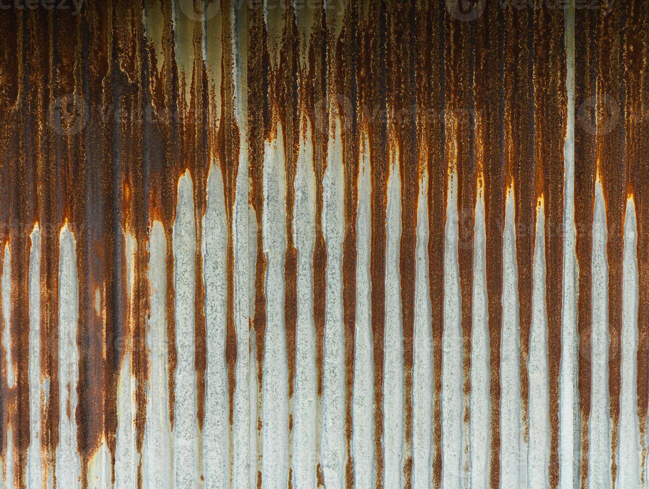 Rust patterns on a metallic surface illuminated by soft sunlight in an urban setting photo