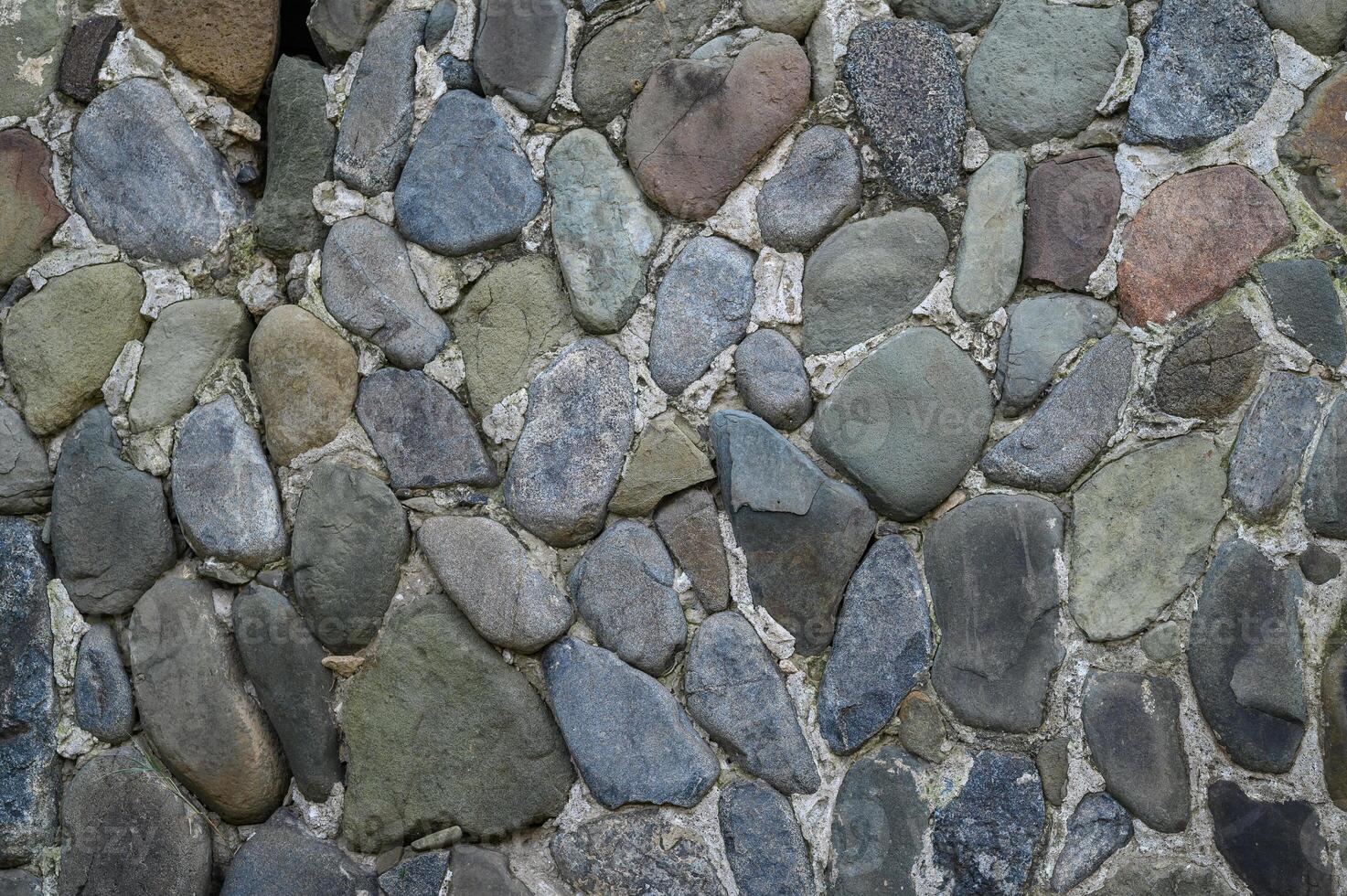 Natural stone wall creates rustic charm in a serene garden setting at dusk photo