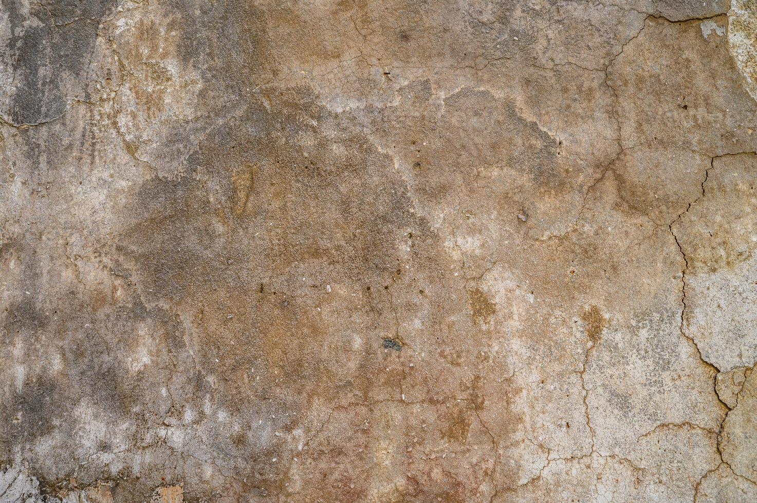 Weathered wall texture showcasing natural colors and cracks from years of exposure in an urban environment photo