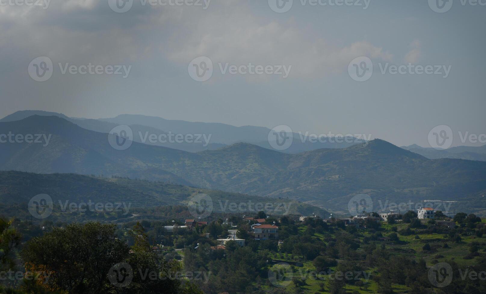 Breathtaking landscape view of mountains with a peaceful village nestled among lush greenery photo