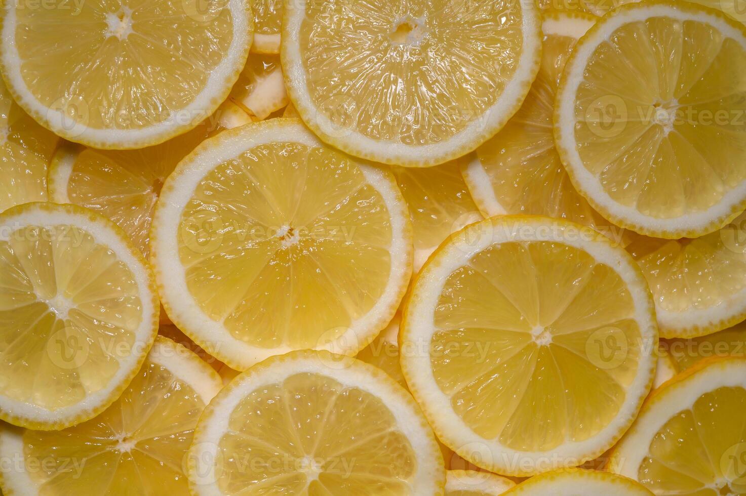 Bright yellow lemon slices create a vibrant and refreshing pattern for culinary inspiration and decor photo