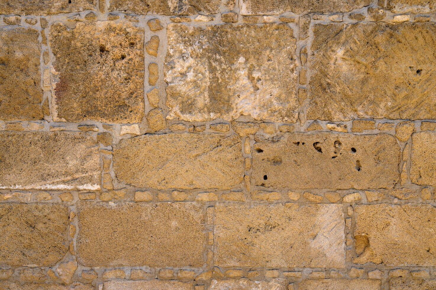 Texture of aged stone wall with warm tones and intricate details from a historic building photo
