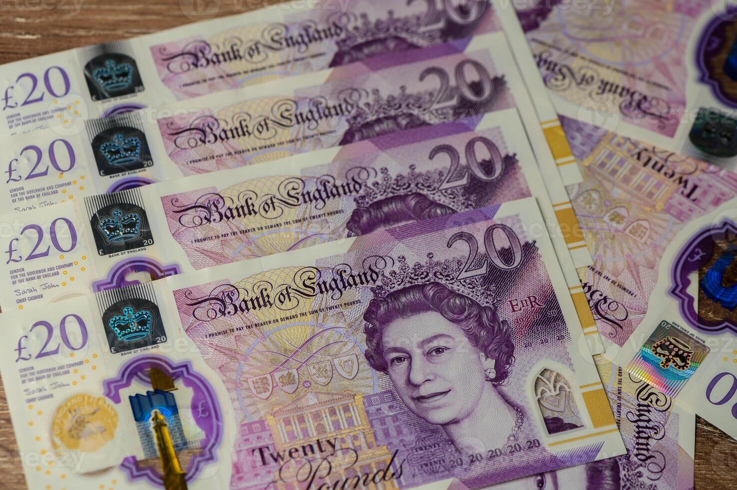 Colorful British currency stacked elegantly on a wooden surface showcasing intricate designs and royalty photo