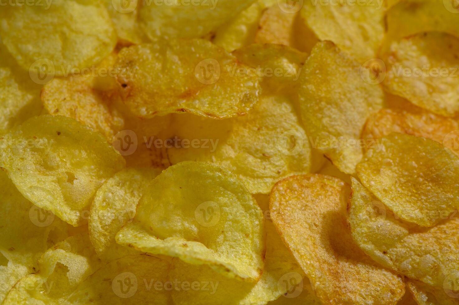 Crunchy potato chips scattered on a rustic surface bring a delightful snack experience photo