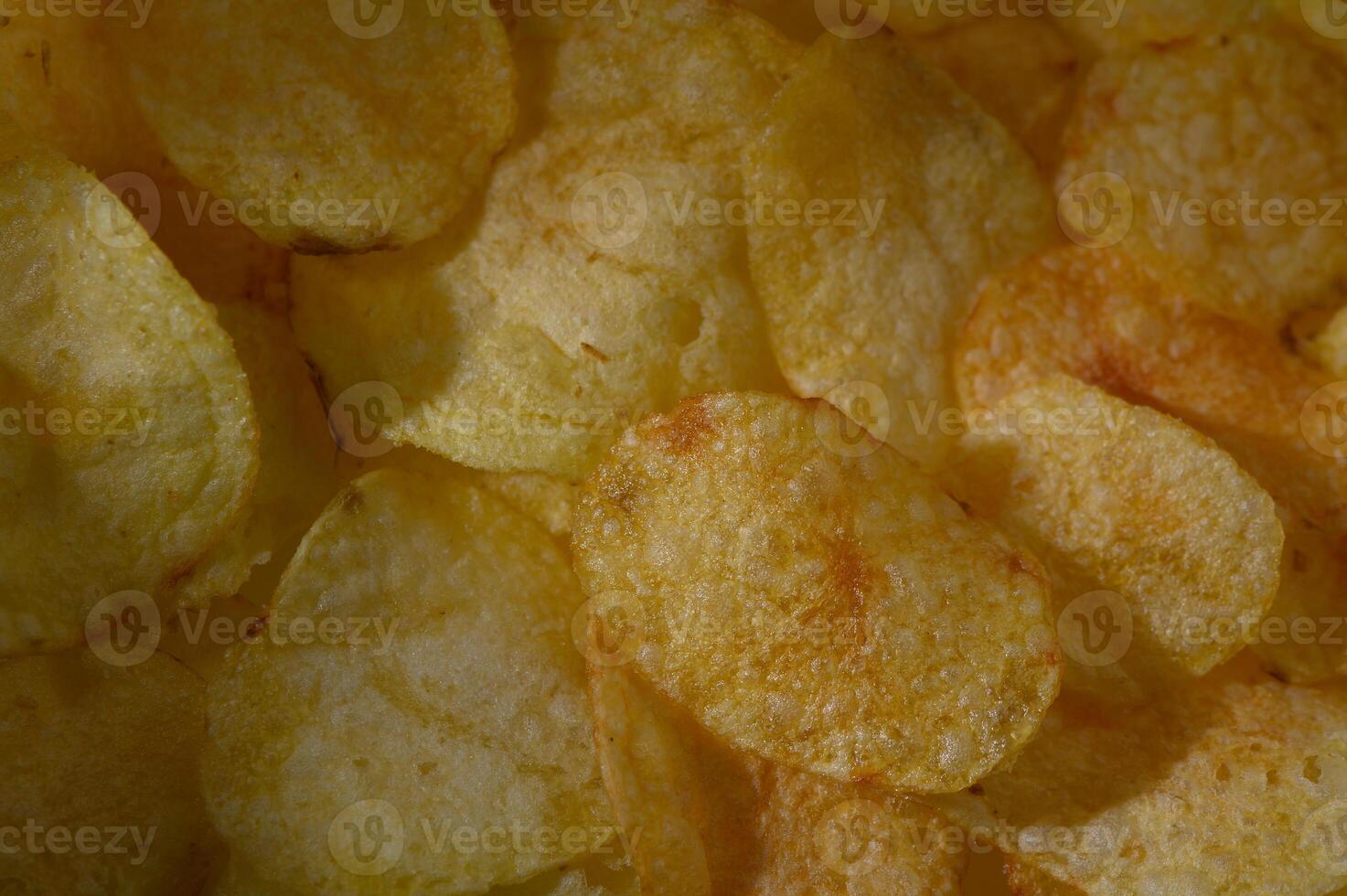 Golden potato chips glisten under warm light, inviting a crunchy snack moment full of flavor and nostalgia photo