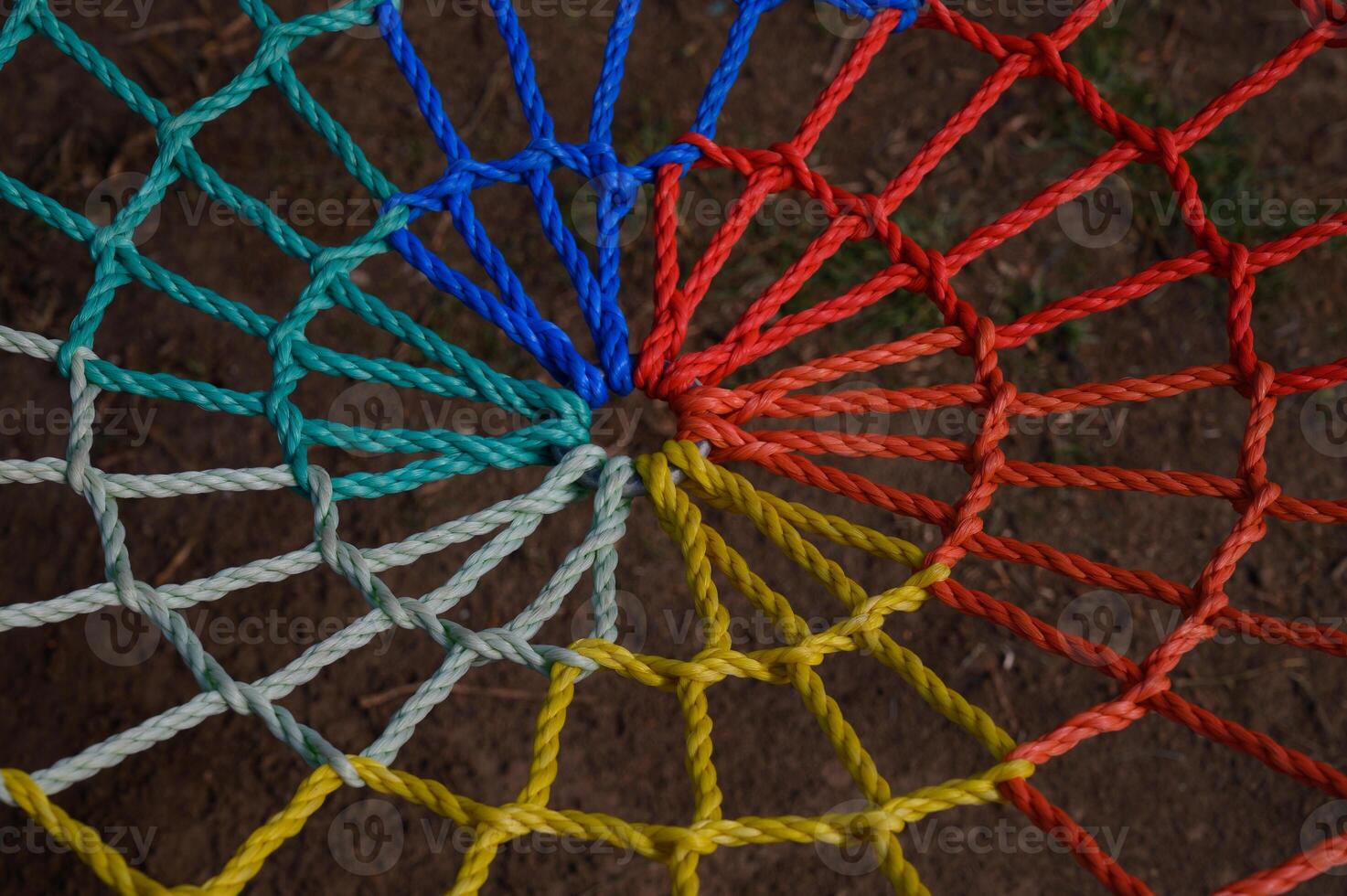 Colorful spiral design of intertwined ropes creates a mesmerizing pattern on the ground photo