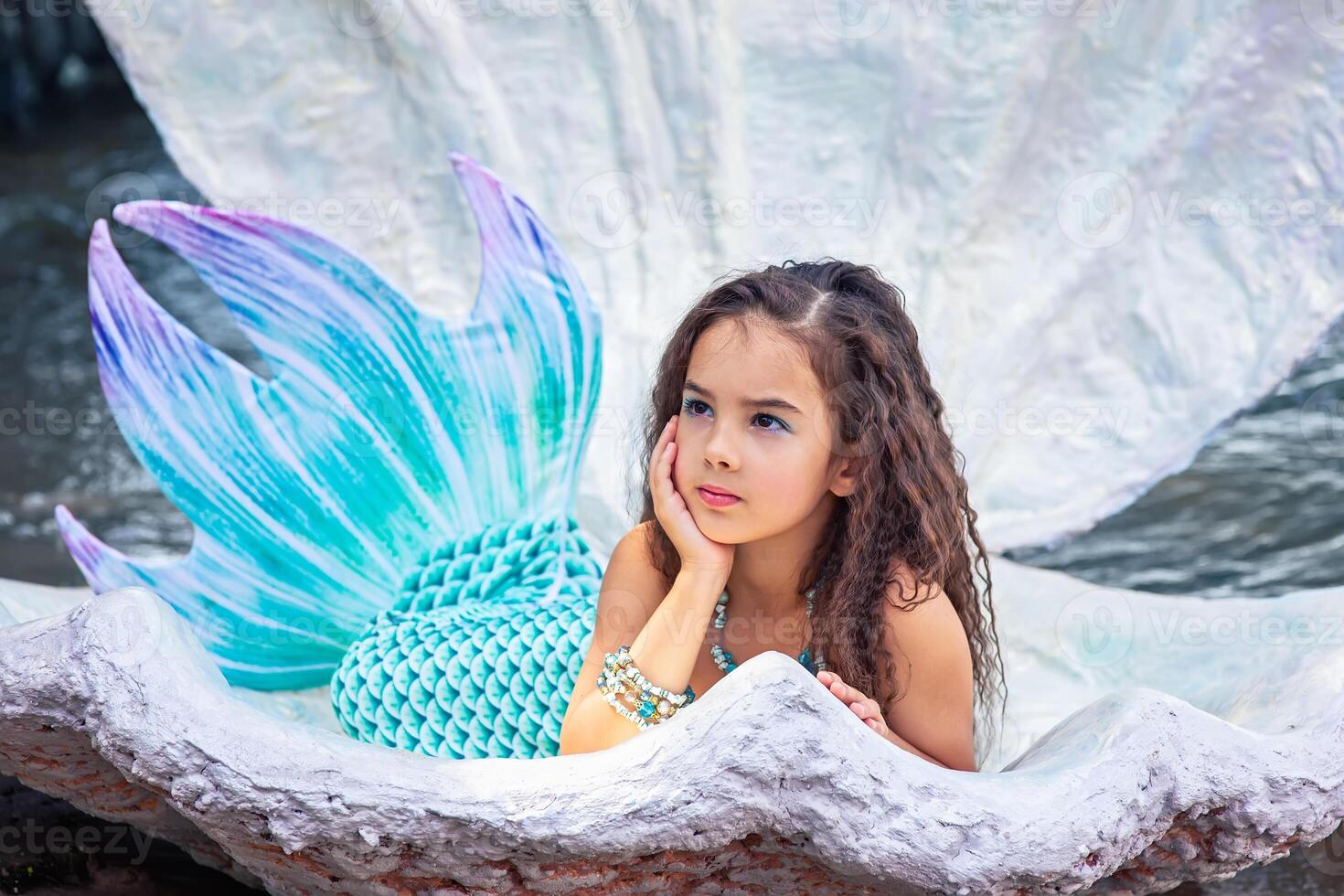 A beautiful girl in a mermaid costume in a large sea shell photo