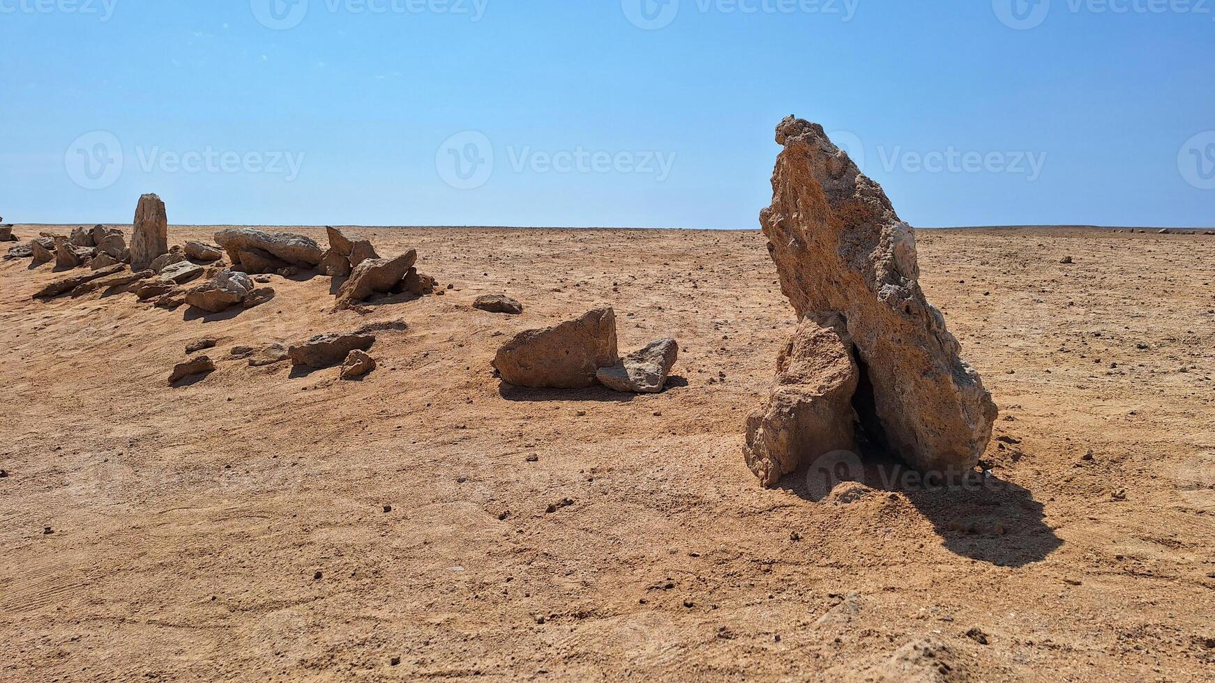 A row of stones stands in the desert, used as a direction for movement photo