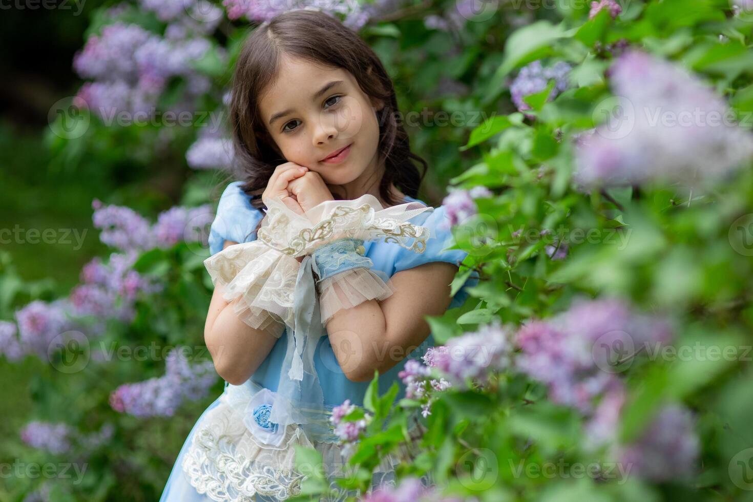 Caucasian young girl in blue dress with flowers in garden photo