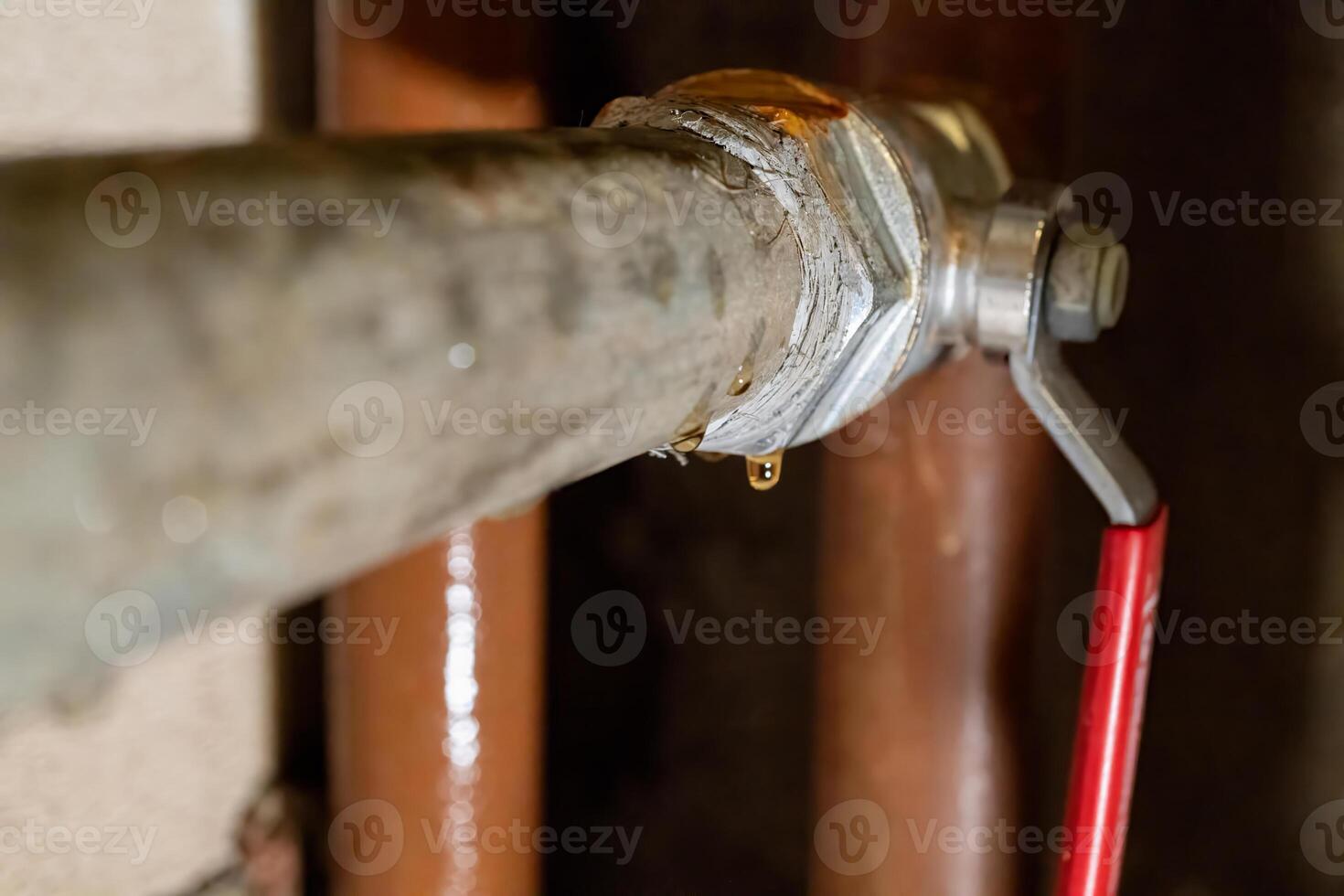 Close-up of leaking pipe with valve in industrial setting photo